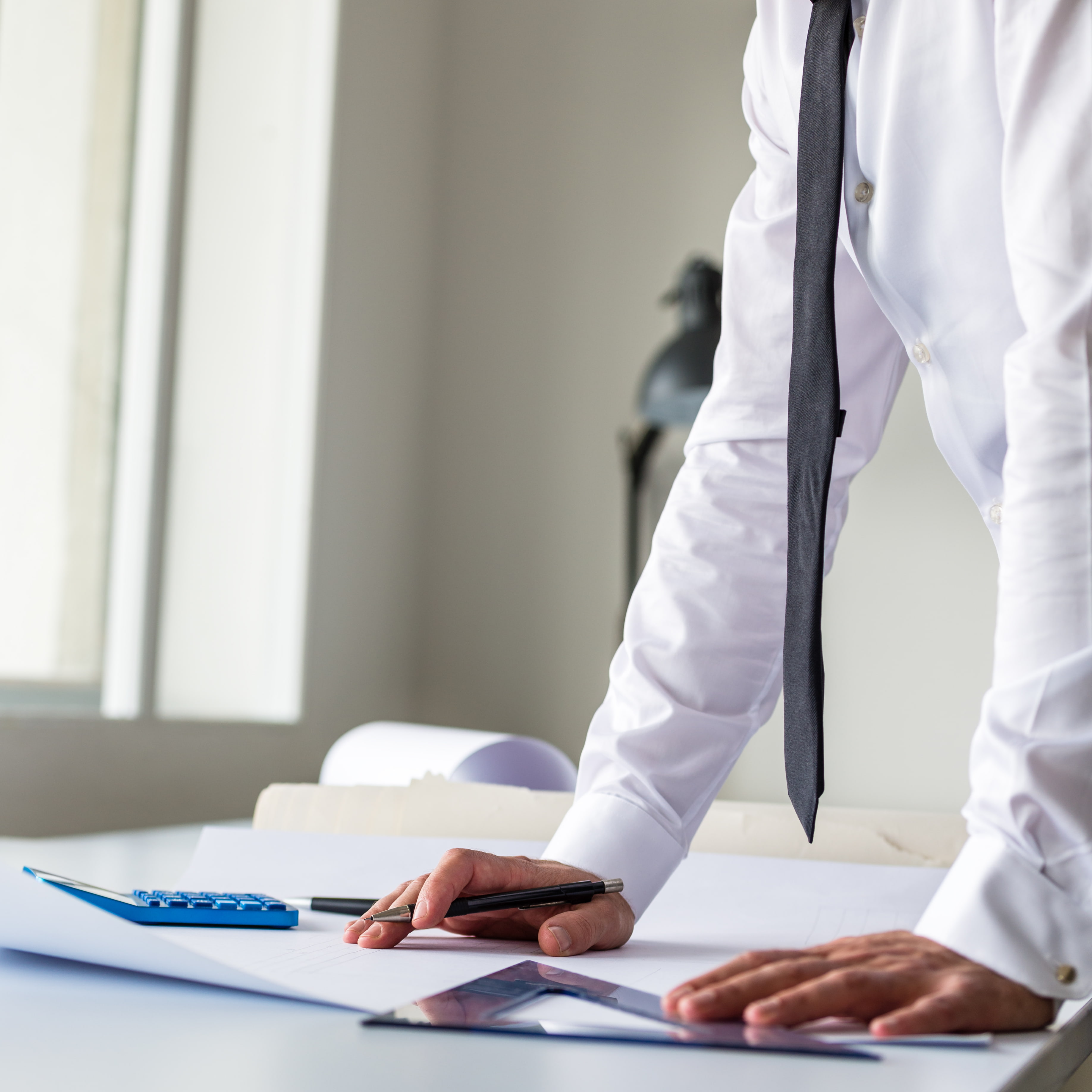 Empresaria eligiendo asesoría fiscal en Madrid, comparando opciones en portátil con documentos y calculadora sobre la mesa.